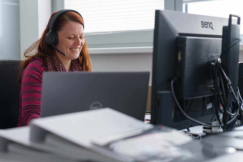 Kundenberaterin mit Headset am Schreibtisch