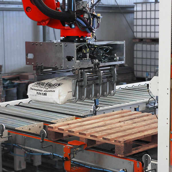 Roboterarm positioniert Sack oberhalb der Palette