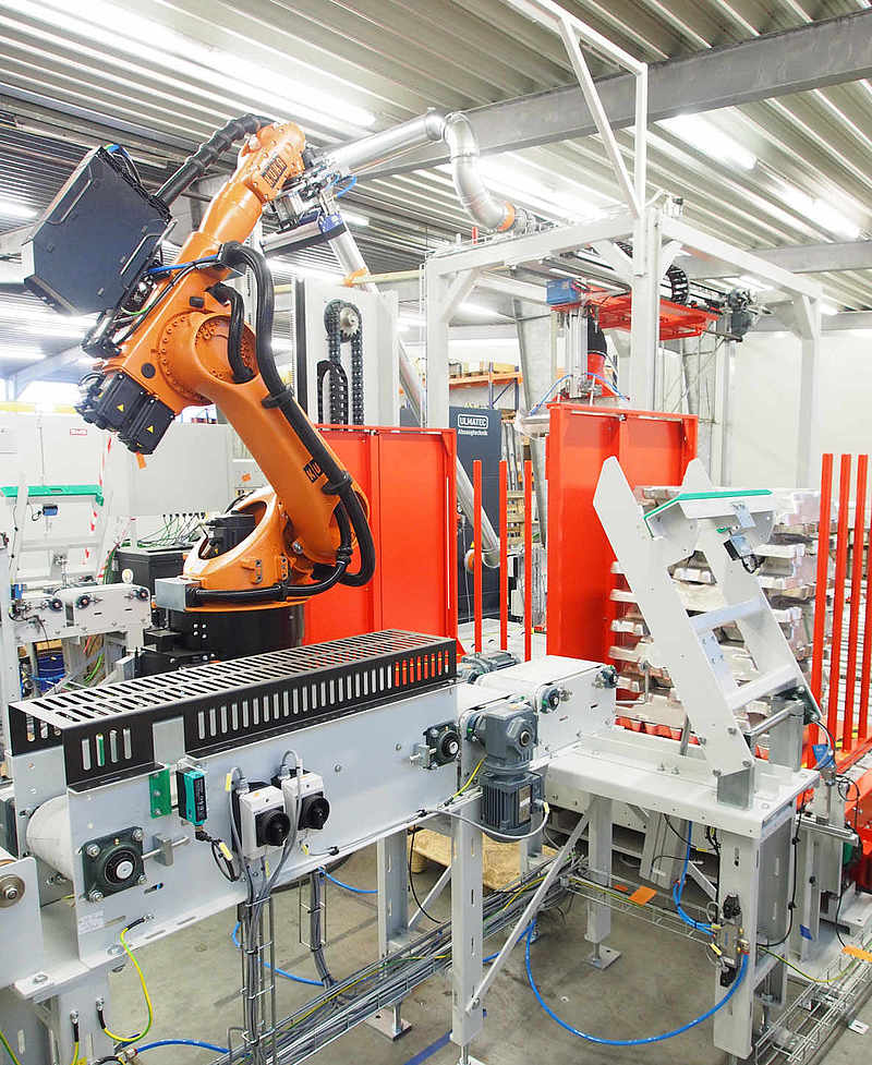 Entnahme eines Sacks durch Roboterarm des Sackpalettierers