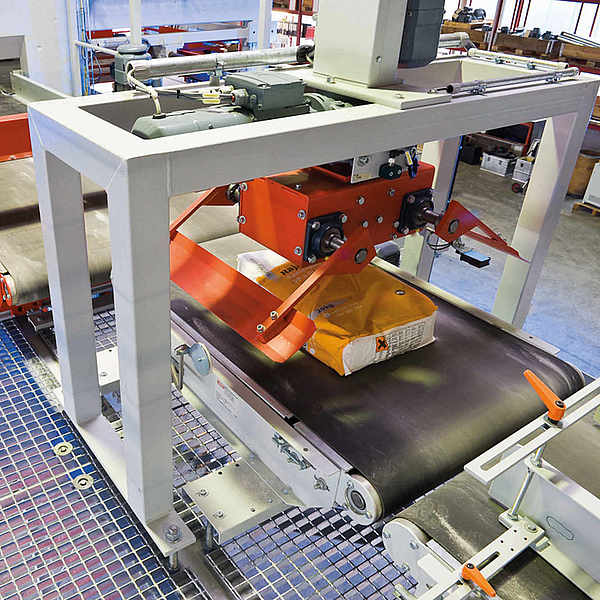 Roboterarm mit Kombigreifer legt Sack auf Modulband