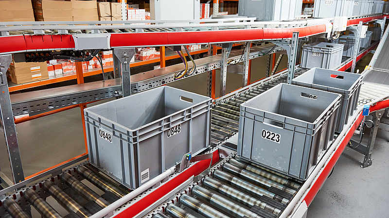 automatische Kommissionierung von Kisten auf Rollenbahnen